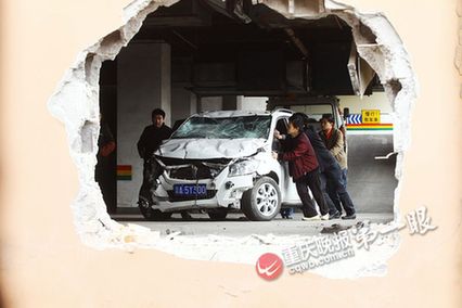 车主将油门当刹车 轿车撞穿大厦墙面悬空