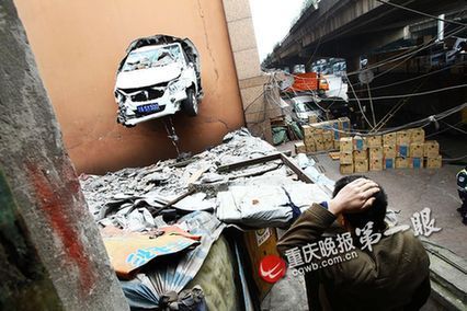 车主将油门当刹车 轿车撞穿大厦墙面悬空