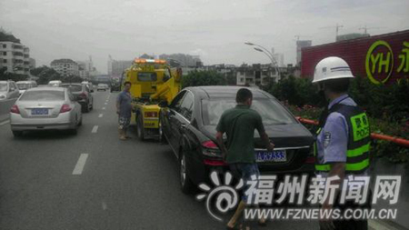 司机弃车买油 豪车拖车将堵路的豪车拖离