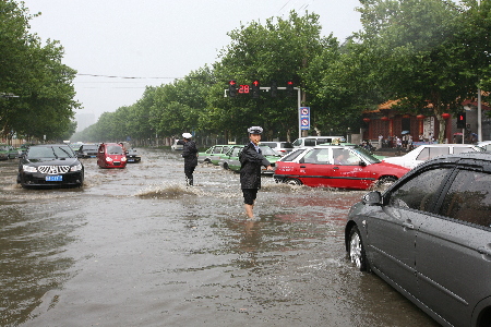 郑州今夏第一场强降雨来临 交巡警冒雨疏导交通