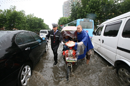 郑州今夏第一场强降雨来临 交巡警冒雨疏导交通