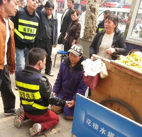 武汉摊贩因车辆被扣下跪求情 城管与其“对跪”
