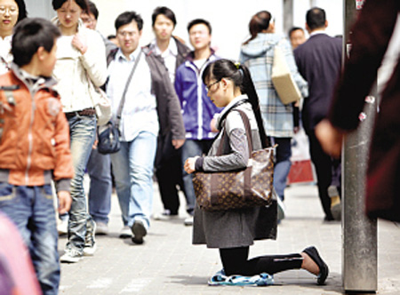 女子挎LV包跪地乞讨
