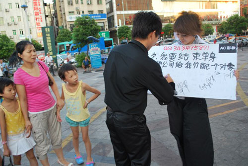 女职员当街举牌要公司分配对象 遭公司罚款(图)