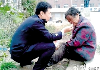 迷途老人街头晕倒 民警对其救助喂吃喂喝(图)