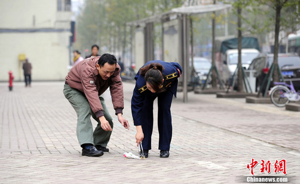 重庆城管佩带蛋糕夹上街拾垃圾