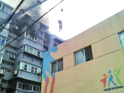 大火逼老人退阳台千钧一发 “吊车哥”升空救人