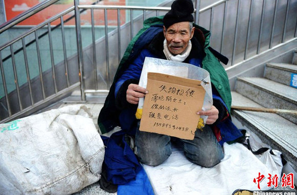 八旬乞丐捡银行卡后举牌寻失主 市民纷纷伸援手
