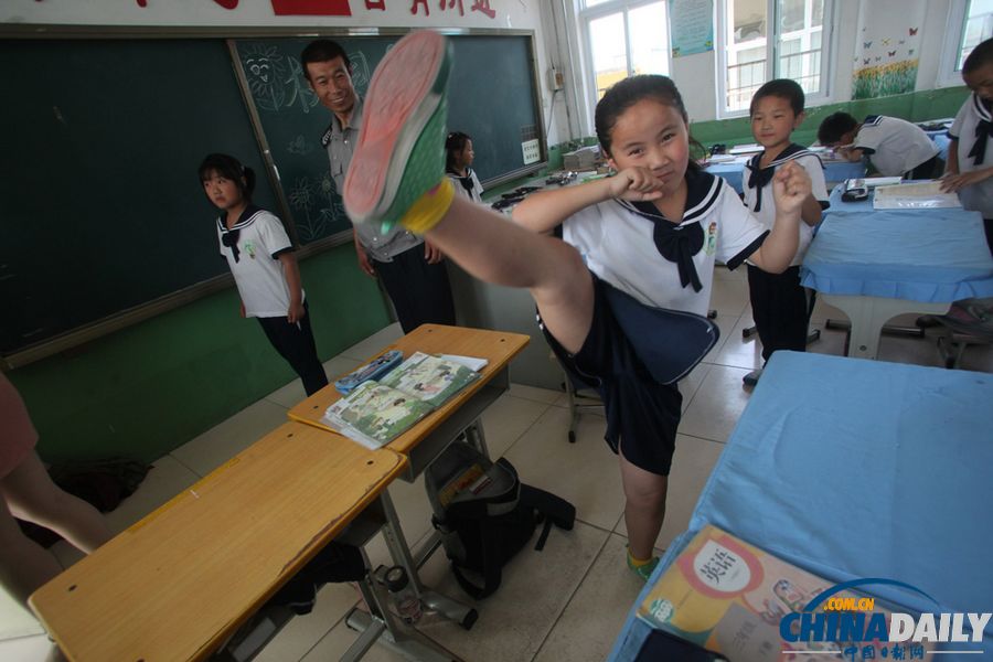 2013年5月30日,在济南黄台小学教室里,一名女学生在学练防身术"擒敌拳