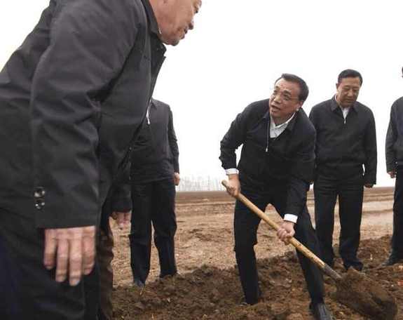 李克强雨中翻地看墒情