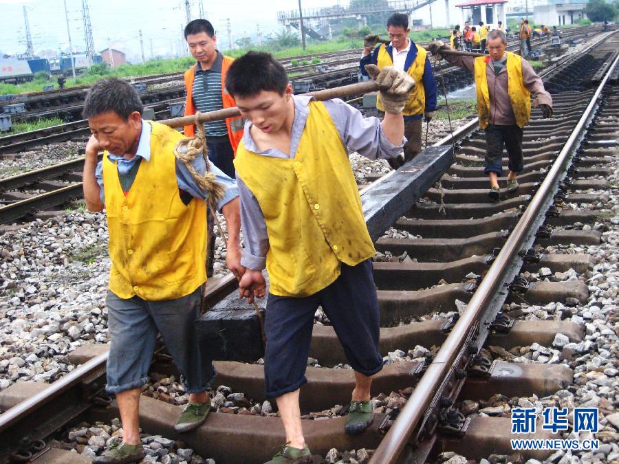 达州火车站铁路工人把新枕木抬运到道床上