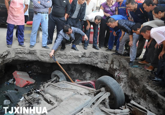 路面现大坑 汽车深夜坠入