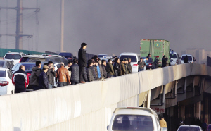 高速公路边仓库起火 围观人群占据3条车道(图)