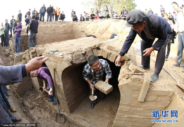 2012年11月1日,河南商丘,文物工作人员正在古墓出土现场清理墓室.