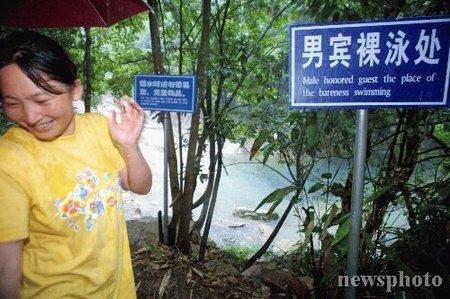 A woman flushes upon reading a notice that says Naked Swimming Allowed 