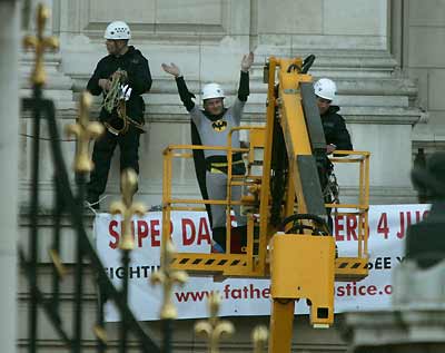 Father's rights campaigner Jason Hatch, dressed as Batman, gestures as he protests on a balcony at Buckingham Palace in London, September 13, 2004. Hatch from the fathers' rights group staged a dramatic protest on a Buckingham Palace balcony on Monday. Police, faced with their second major security breach in four months, tried in vain to talk down the protester from Queen Elizabeth's London residence. [Reuters]