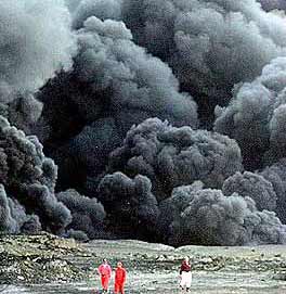 Iraqi firemen walk in front of heavy black smoke billowing from a sabotaged key pipeline pumping oil exports from northern Iraq to Turkey and a local supply line west of the main northern oil capital of Kirkuk. [AFP] 