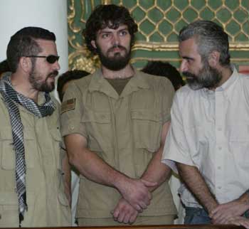 US citizens Jonathan Idema (L) and Edward Carabello (R) talk to each other as Brent Bennett listens at a district court in Afghan capital Kabul, September 15, 2004.[Xinhua]
