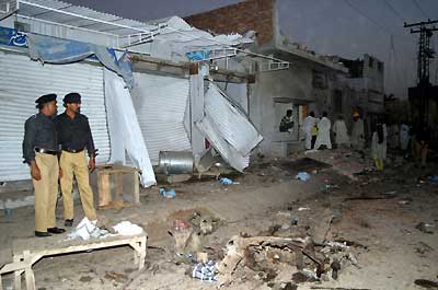 Pakistani policemen survey the damage caused by a car bomb explosion in central city of Multan October 7, 2004. At least 39 people were killed and more than 80