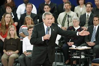 Democratic presidential nominee John Kerry (L) and U.S. President George W. Bush listen to a question from the audience during the town hall format debate at Washington University in St. Louis Missouri, October 8, 2004. The latest polls have the two candidates in a statistical dead heat with about three weeks until the election and one final debate in Arizona next week.