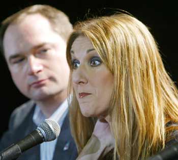 Canadian diva Celine Dion answers questions from the media as Air Canada chief executive Robert Milton looks on at their Montreal headquarters on October 19, 2004. The airline which emerged from bankruptcy protection last month held a launch party for its employees at which Dion sang. [Reuters]