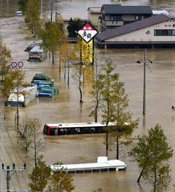 Trucks and buses are submerged in a river flood after deadly Typhoon Tokage brought heavy rain to the western Japanese city of Maizuru Japan October 21, 2004. Rescuers across Japan were searching for survivors on Thursday after Japan's deadliest typhoon in a decade triggered floods and landslides, local reports said. [Reuters]
