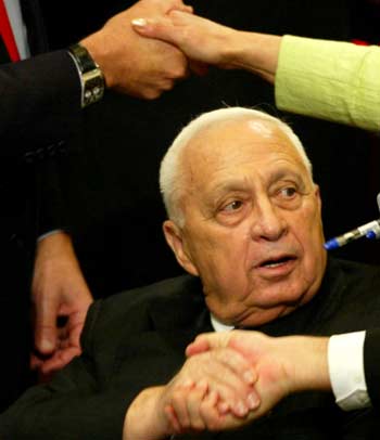 Israeli Prime Minister Ariel Sharon receives congratulations following a vote on his plan to withdraw from Gaza at the Israeli parliament in Jerusalem October 26, 2004. After a fierce two-day debate, legislators voted 67-45, with seven abstentions, for the U.S.-backed pullout. [Reuters]