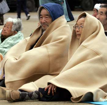 Earthquake victims take refuge outside an evacuation centre following a strong earthquake in Nagaoka, northern Japan October 27, 2004. A strong earthquake with a preliminary magnitude of 6.0 jolted northern Japan on Wednesday, national broadcaster NHK said. The quake was also felt in Tokyo. [Reuters]