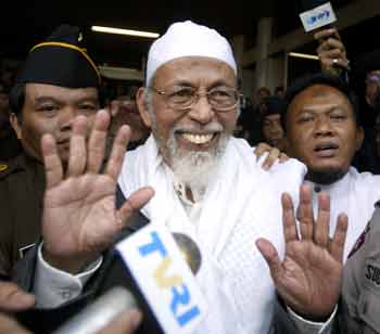 Indonesian Muslim cleric Abu Bakar Bashir waves as he leaves a makeshift courtroom of an auditorium at the Agriculture Department in South Jakarta on October 28, 2004. Bashir went on trial on Thursday accused of leading an al Qaeda-linked militant network and of planning or inciting them to carry out attacks in the world's most populous Muslim nation.