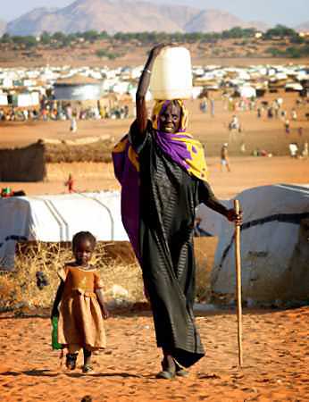 A displaced Sudanese woman carries water October 31, 2004 at the Abushouk camp near El Fasher, the capital of North Darfur province. Mediators urged the Sudanese government and two Darfur rebel movements November 1, 2004 to sign a security agreement they hope will end violence that has driven more than 1.5 million people from their homes. [Reuters]