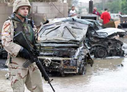A US soldier secures the scene of a car bomb attack in Baghdad, November 2, 2004. The blast brought fresh carnage to the streets of Baghdad, killing at least five people, two of them women, at the Education Ministry. [Reuters]