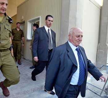 Palestinian Prime Minister Ahmed Qurei (R), escorted by an Israeli soldier working at the Alenbey Bridge crossing point between Israel and Jordan, as he leaves the V.I.P terminal on his way to Paris November 8, 2004. Palestinian leaders headed for Paris to see critically ill President Yasser Arafat at a French military hospital despite a scathing attack by his wife who accused them of plotting to "bury him alive". Amid an increasingly bitter row over Arafat's fate, Prime Minister Ahmed Qurie, Foreign Minister Nabil Shaath and PLO Secretary General Mahmoud Abbas were on route to Jordan, from where they planned to fly to France aboard a private jet. [Reuters]