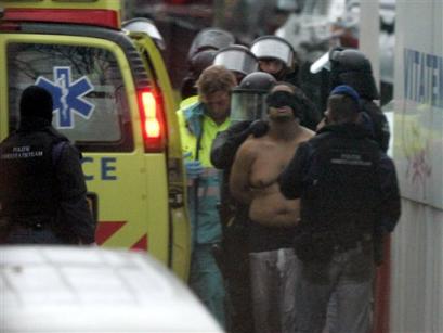 A blind-folded unidentified suspect is arrested in the Hague, Netherlands, on Wednesday Nov. 10, 2004. Dutch special forces stormed a house Wednesday and arrested two terror suspects, ending a 15-hour siege in which sporadic gunfire was exchanged and three police officers were wounded. [AP]