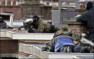 Snipers of the Dutch police point their guns to an apartment in The Hague. Dutch police stormed the apartment and arrested two people, ending a 14-hour stand-off that began when suspects sought in an anti-terrorism probe wounded three officers with a hand grenade. [AFP]