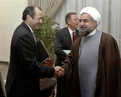 Iran's top nuclear negotiator and secretary of the Supreme National Security Council Hasan Rowhani, right, shakes hands with British ambassador to Iran Richard Dalton, in front of German ambassador Paul von Maltzahn at the Saadabad palace in Tehran, Iran, Sunday, Nov. 14, 2004. [AP]