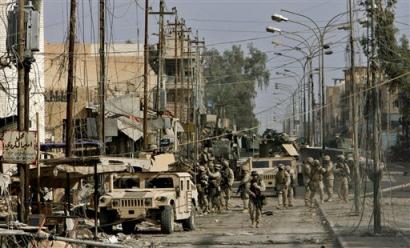 U.S. Marines of the 1st Division push further into the western part of Fallujah, Iraq, Sunday, Nov. 14, 2004. The U.S. military's ground and air assault of Fallujah has gone quicker than expected, with the entire city occupied after six days of fighting, the Marine commander who planned the offensive said Sunday. [AP]
