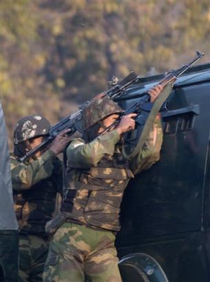 Indian Border Security Force soldiers fire towards militant positions during a gun battle in Srinagar, India, Wednesday, Nov.17, 2004. Hours before Indian Prime Minister Manmohan Singhs visit to Srinagar, the summer capital of India's Jammu-Kashmir state, militants attacked a paramilitary picket injuring two soldiers and a civilian. At least two militants lobbed grenades and fired at soldiers on guard duty outside an office complex located less than a mile away from a sports ground where Singh was to address a public meeting. [AP]