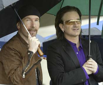 U2 lead singer Bono (R) and The Edge wait to perform at the dedication ceremony for the William J. Clinton Presidential Library November 18, 2004 in Little Rock, Arkansas. Thousands gathered in a pouring rain for the event. [Reuters]
