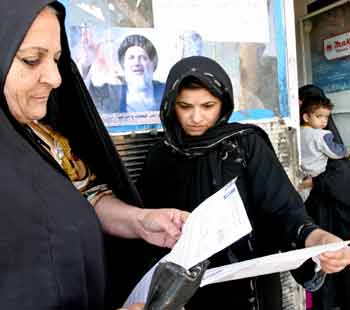 Iraqi women read the registration forms of the coming Iraqi elections in the capital Baghdad, November 22, 2004. Iraq's interim government voiced confidence on Monday that an election it has scheduled for Jan. 30 will go ahead despite violence and intimidation in some areas and a threat of a boycott by the once dominant Sunni minority. [Reuters]