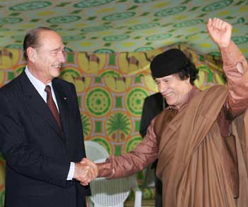 Libyan leader Muammar Gaddafi (R) clenches his fist as he shakes hands with French President Jacques Chirac (L) November 24, 2004 at Bab Azizia palace in Tripoli. Chirac started a two-day visit in Libya on Wednesday. [Reuters]