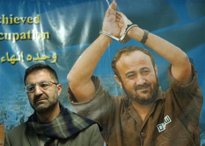 Backdropped by a poster of jailed Palestinian uprising leader Marwan Barghouti, Abdel Rahaman Shomali, a member of the Fatah Higher Committee, one of Fatah's key institutions talks to the media at Barghouti's campaign office in the West Bank city of Ramallah, Thursday, Nov. 25, 2004. Barghouti, a fiery young Palestinian leader, made it known Thursday that he is running for Yasser Arafat's position as head of the Palestinian Authority. [AP]
