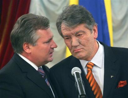 Ukrainian opposition leader Viktor Yushchenko, right, and Polish President Alexander Kwasniewski, chat as they listen to Ukrainian President Kuchma's statement after their negotiations in Kiev, Ukraine, Friday, Nov. 26, 2004. Kuchma, who met with the two men who claim to have won the election to succeed him and top European envoys, said a multilateral working group had been established to find a way out of the crisis that has brought hundreds of thousands of supporters of losing candidate Viktor Yushchenko into the streets. [AP]