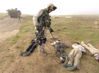 A U.S. Army soldier checks for possible booby-traps and explosives after the bodies of four murdered men were found in a cemetery in Mosul, Iraq, Sunday, Nov. 28, 2004. Ten bodies were recovered Sunday in Mosul, where at least 50 people have been murdered in the past 10 days. Most of the victims are believed to have been supporters of Iraq's interim government or members of its fledgeling security forces.