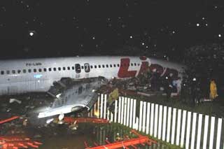 Rescuers examine the wreckage of Lion Air passenger plane after it skidded off the runway in Solo, Central Java, Indonesia, Tuesday, Nov. 30 , 2004. The accident killed at least 12 people and injuring more than 50 others. (AP 