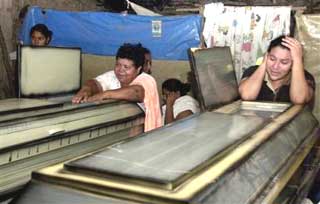 Relatives cry in front of the coffin of two children who died in a sugar cane fire in Santa Cruz, some 170 kilometers (100 miles) south of Tegucigalpa, on Monday, Nov 29, 2004. At least 13 children were killed in a sugar cane fire, apparently while they hunted rabbits that were fleeing the flames, authorities said Tuesday. (AP