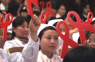 Chinese nurses holding up red ribbon cutouts during a ceremony held to mark World AIDS Day in Beijing Wednesday, Dec. 1, 2004. The number of people contracting the AIDS virus in China is rising and infections are spreading from high-risk groups such as drug users to the general population, according to a study released Tuesday. (AP 