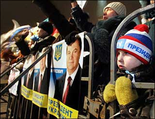 A boy looks through a barrier while supporters of Ukraine's Premier and presidential candidate Viktor Yanukovich wave flags and shout during a rally in Donetsk, the center of the powerful Russian-speaking eastern region.(AFP