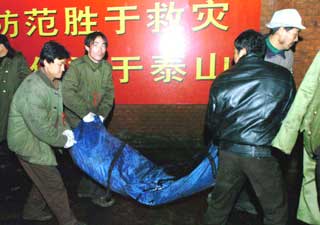 A body of one of the miners is carried out of the mine pit of the Chenjiashan coal mine in Shaanxi Province in the early hours of Wednesday. It has been confirmed all of the over 100 trapped underground in the explosion were dead, bringing the death toll in the accident to 166. [Xinhua]