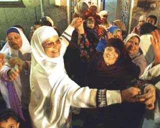Um Mustafa, mother of Mustafa Mahmoud one of the six free Egyptian students who was captured sneaking into Israel and jailed since August, left, celebrates with her relatives and neighbours marking the release of her son Sunday Dec. 5, 2004 in Cairo. Israel and Egypt reached a deal Sunday to free six Egyptian students captured sneaking into Israel and jailed since August, in a prisoner's swap with Azzam Azzam, the convicted Arab-Israeli man jailed since 1996. (AP 