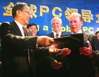 Lenovo Chairman Liu Chuanzhi (L) exchanges documents with John Joyce, Senior Vice-President & Group Executive of IBM Global Services, at a ceremony in Beijing December 8, 2004. 